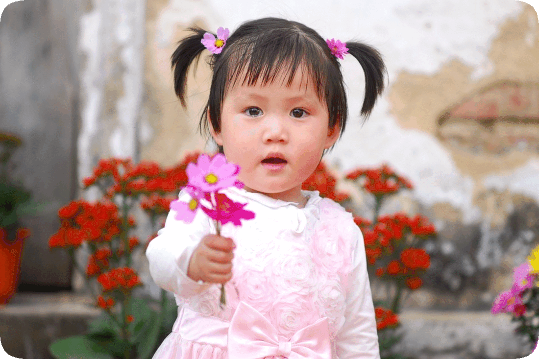 Picture of a child with outstretched hand holding a bouquet of flowers.