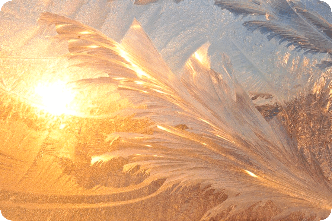 Picture of frost, or fine ice crystals, on a windowpane, with the Sun shining through and the ice starting to melt.