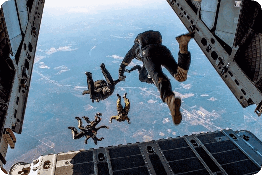 Picture of six skydivers jumping out of a flying airplane.