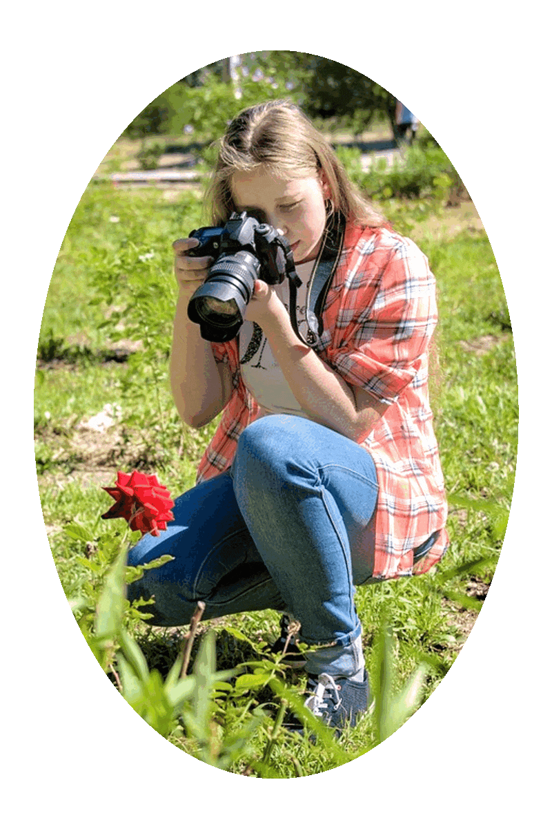 Picture of a woman taking a picture of a  flower.