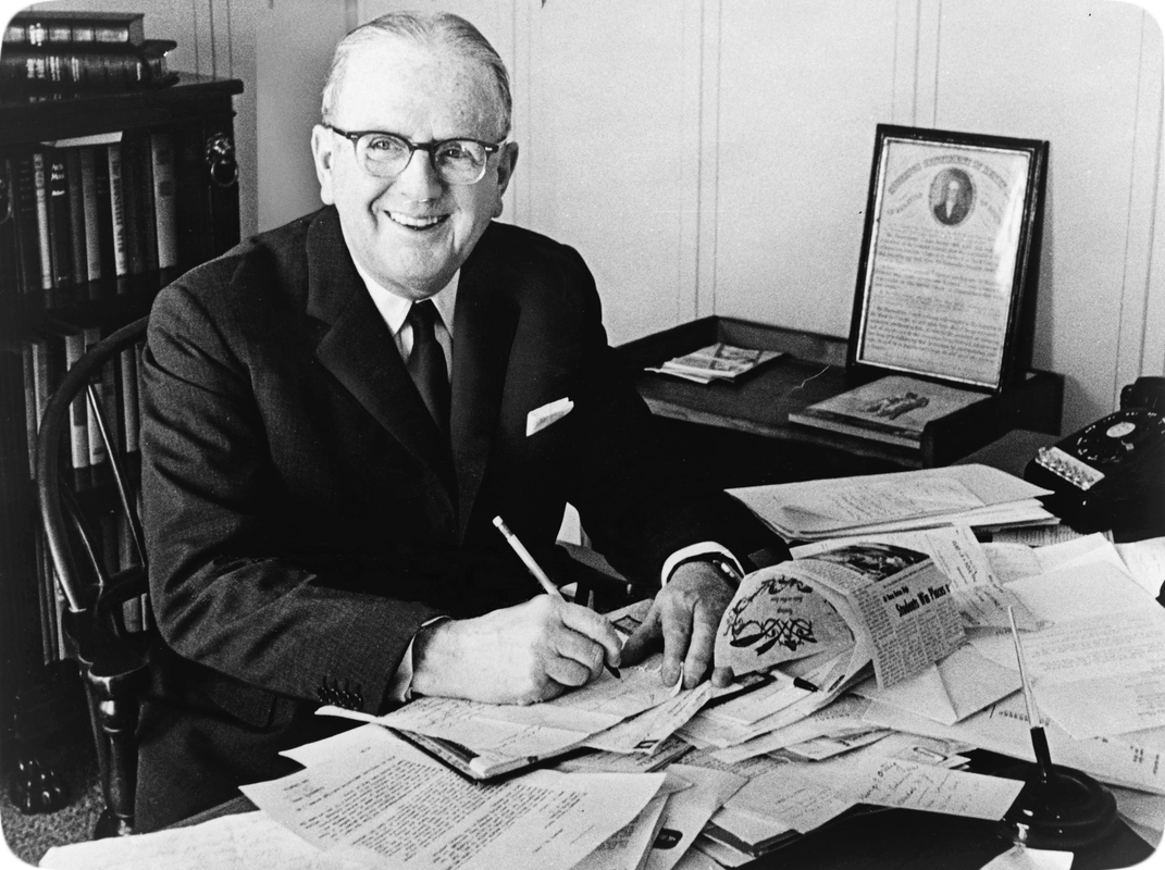 Picture of a happy smiling Norman Vincent Peale working at his desk