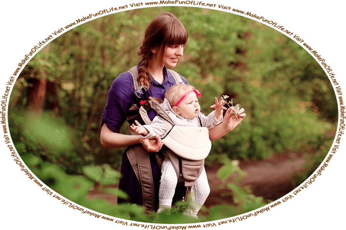 Picture of a happy smiling mother holding a plant to show to her curious young infant child, while the two are outdoors in a wilderness of green leafy trees and dirt footpaths, and the words, ‘Visit www.MakeFunOfLife.net.’