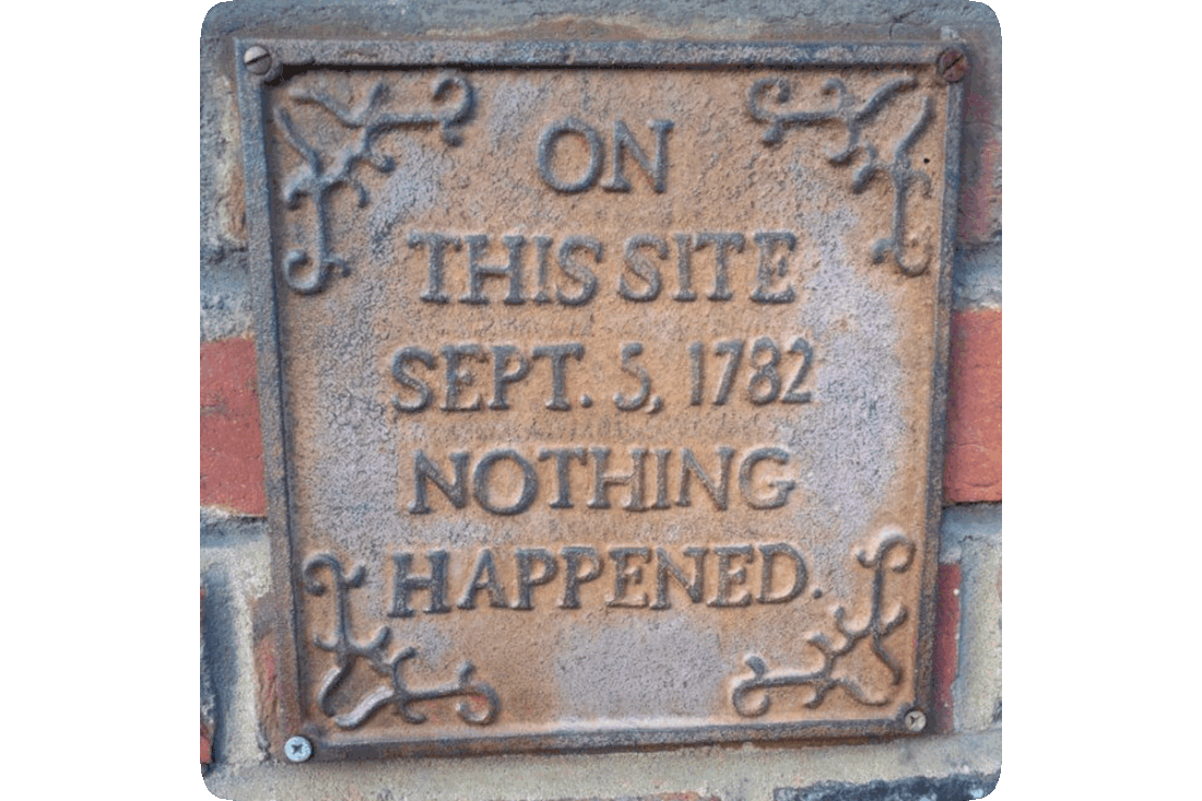 Picture of a brick wall on which is mounted a cast iron plaque reading, ‘On This Site September 5, 1782 Nothing Happened.’