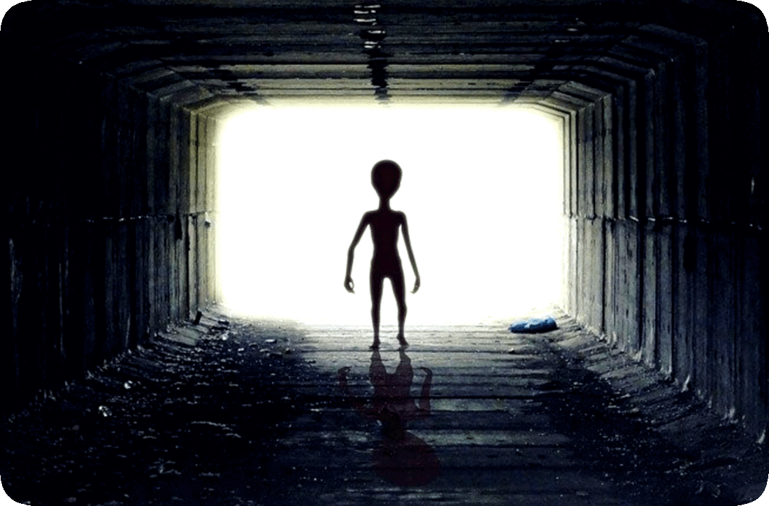 Picture of a humanoid extraterrestrial, or space alien, walking through an underground stormwater runoff conduit.
