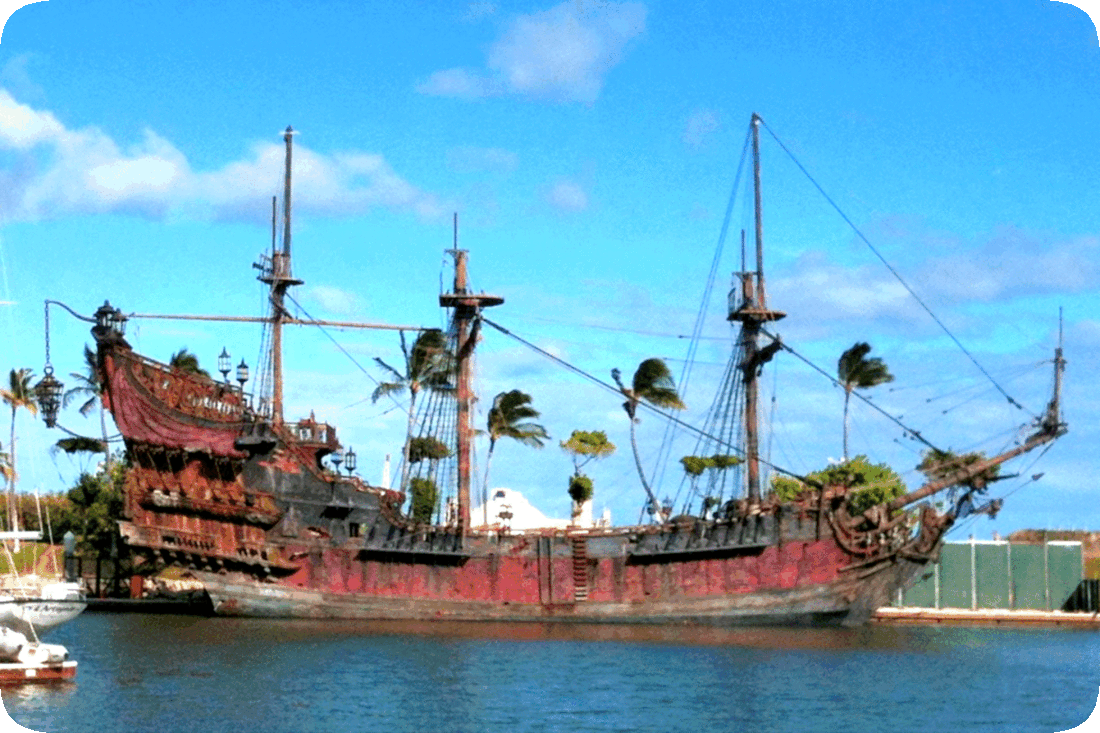 Picture of an old dilapidated sailing ship docked in a harbor.