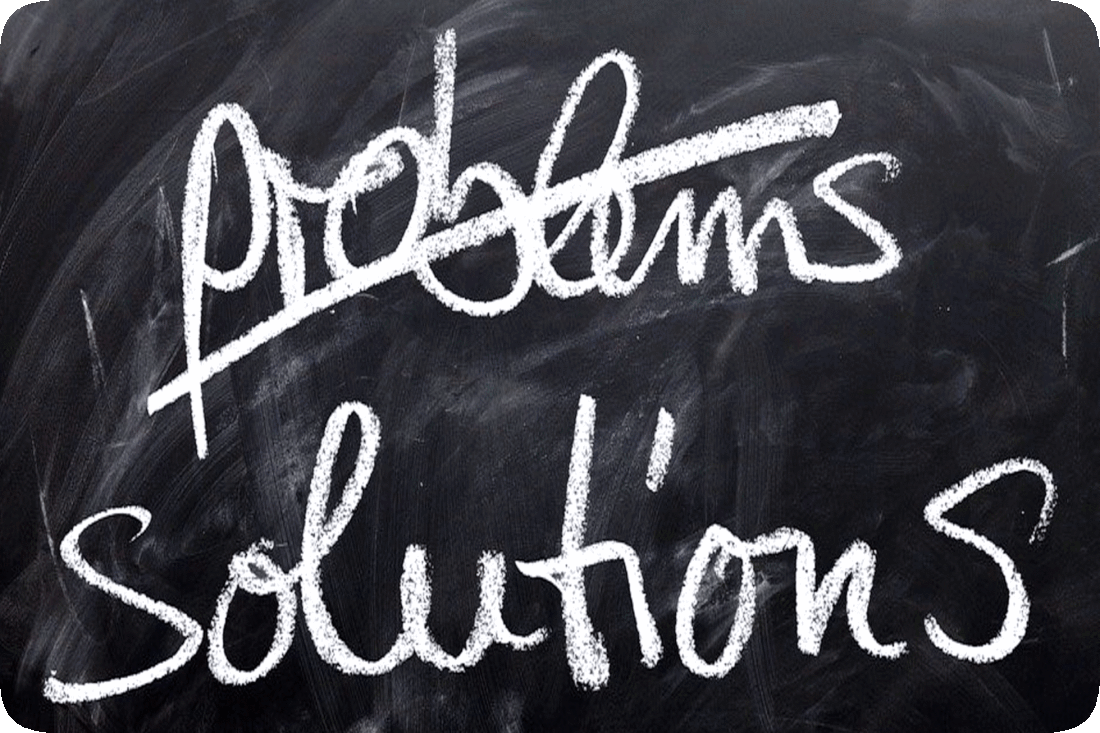 Picture of a chalkboard with words written in chalk, ‘Problems, Solutions,’ and the word ‘Problems’ having a line drawn through it to cross it out.