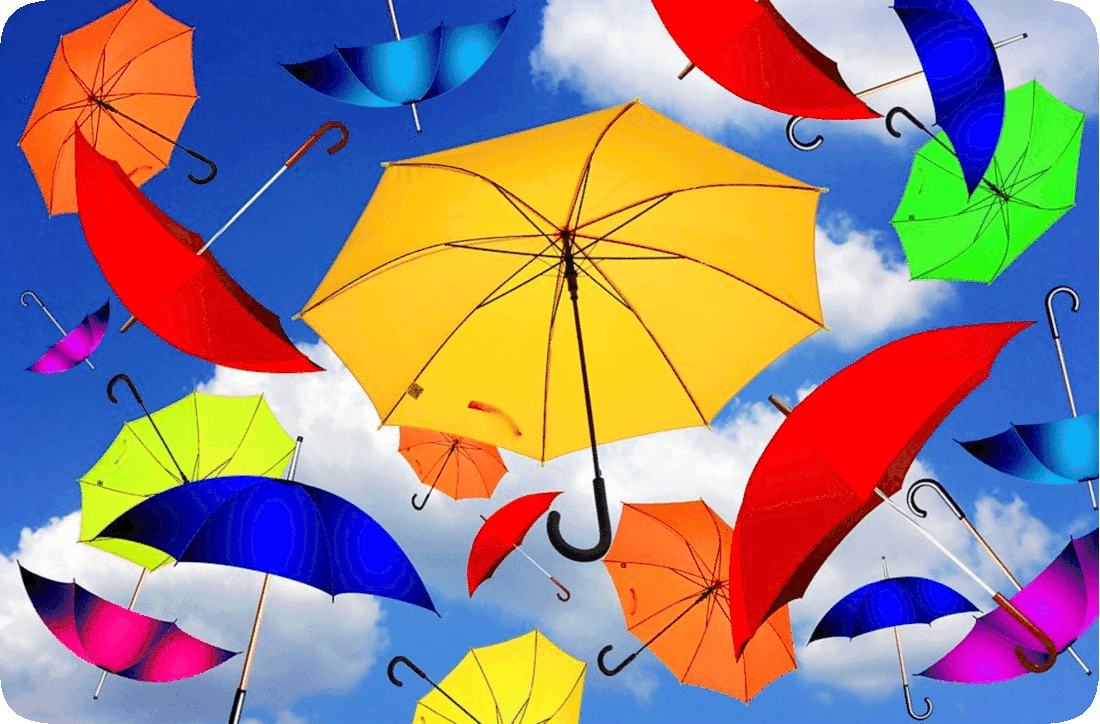 Picture of colorful umbrellas suspended in a blue sky with fluffy white clouds.