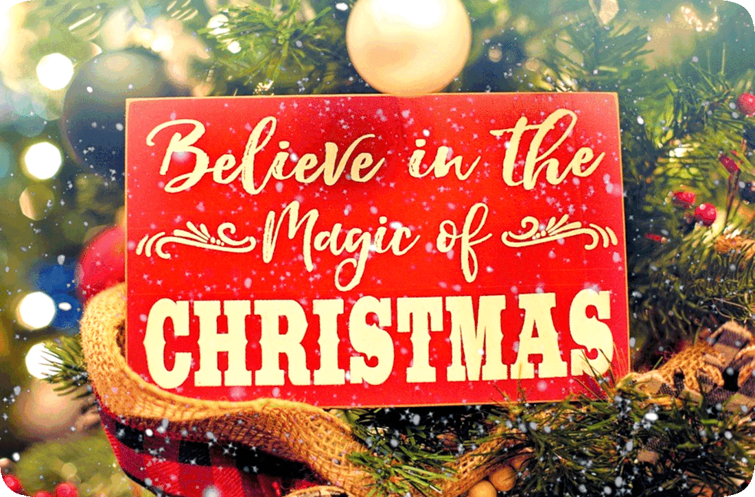Picture of a red sign with the words, ‘Believe in the magic of Christmas,’ hung on a Christmas tree.