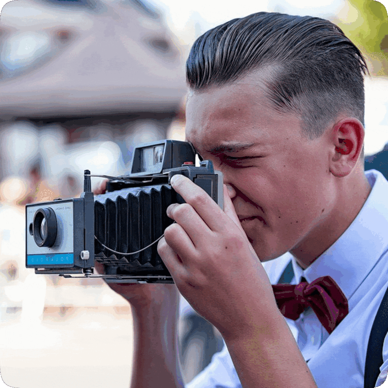 Picture of a young man taking a picture with a camera.