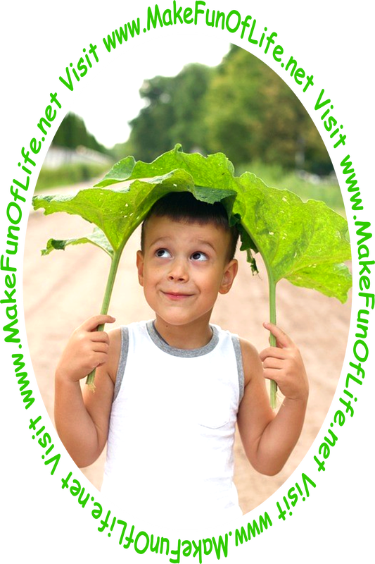 Picture of a happy smiling boy holding two large green burdock plants leaves by the stems, over his head like a hat or umbrella or a parasol sunshade.