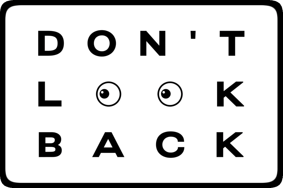 Sign reading, ‘Don’t Look Back,’ with the two letter o’s in the word ‘look’ replaced with eyes looking in a backward direction.