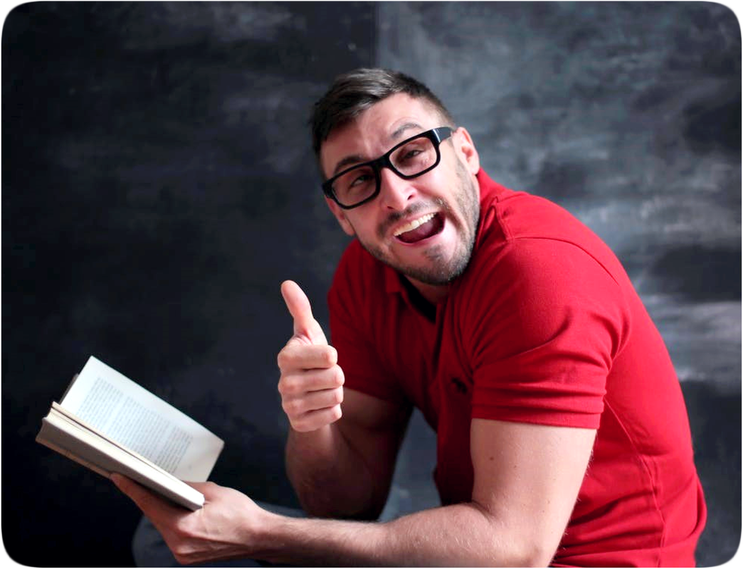 Picture of a man reading a book and giving a thumbs up gesture.