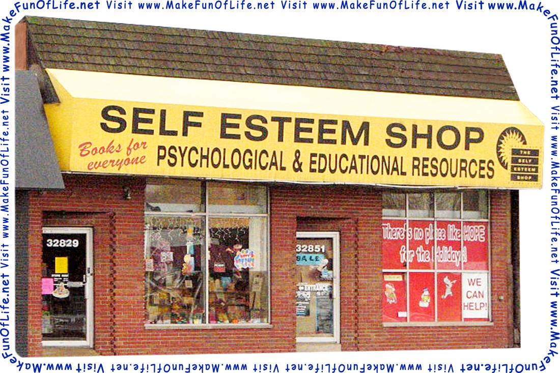 Picture of a shop as seen from a road, with a large sign reading, ‘Self Esteem Shop - Books For Everyone - Psychological And Educational Resources,’ signs in the windows reading, ‘There’s No Place Like Hope For The Holidays - We Can Help,’ and the words, ‘Visit www.MakeFunOfLife.net.’