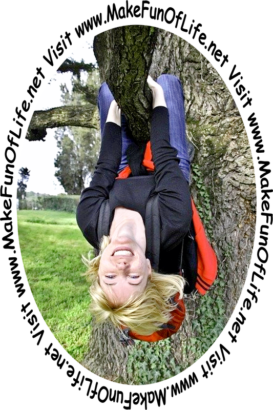 Picture of a happy smiling woman hanging upside down by her arms and legs from a tree branch.