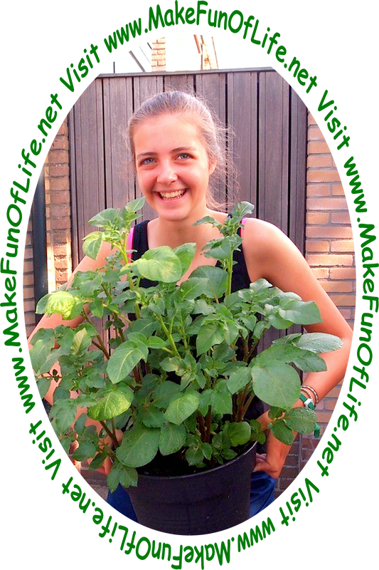 Picture of a smiling happy woman holding a green leafy plant in a black pot filled with soil.