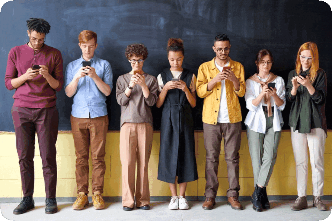 Picture of seven people standing in a line and all looking down at their cell phones.