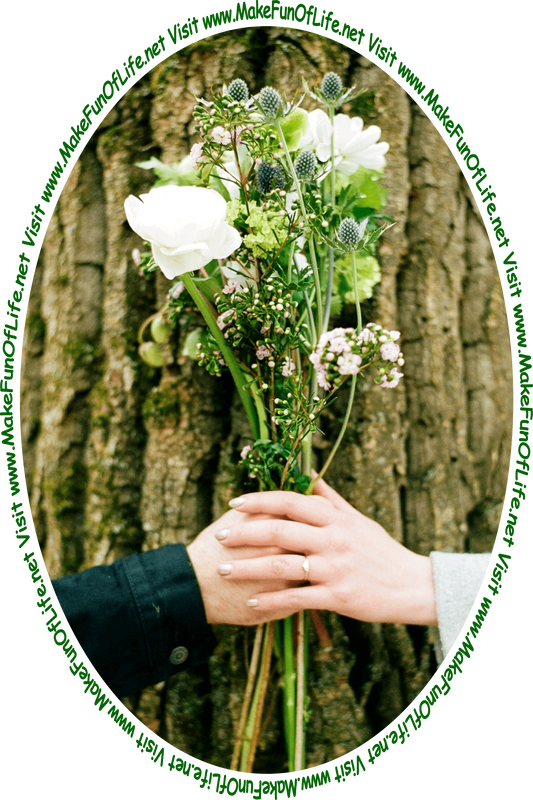 Picture of two people’s hands holding a bouquet of flowers in front of a tree trunk with rough bark, and the words, ‘Visit www.MakeFunOfLife.net.’