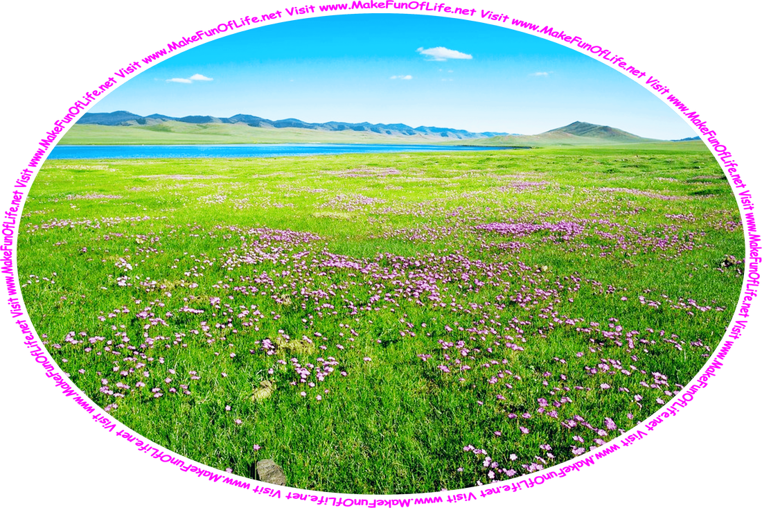 Picture of a green grassy meadow interspersed with lavender colored flowers, a small freshwater lake, hills, a blue sky above with a few tiny clouds drifting in it, and the words, ‘Visit www.MakeFunOfLife.net.’