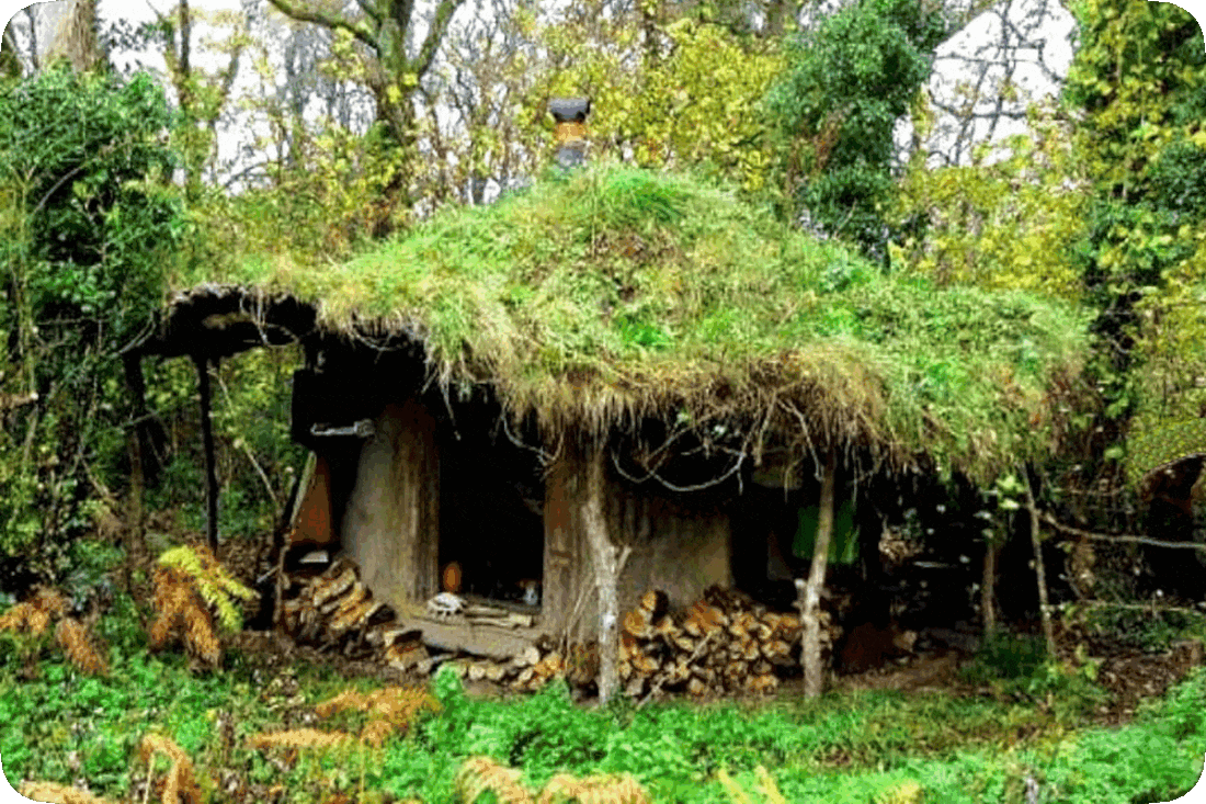 Picture of a thatched-roof cob house, a type of building that has walls made of a mixture of clay, sand, and straw.