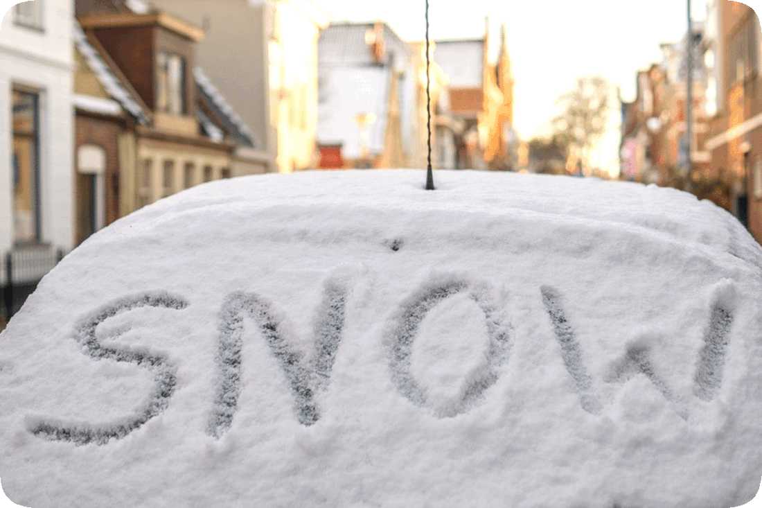 Picture of an automobile’s rear window covered in snow, on which has been written with a finger the word, ‘Snow.’